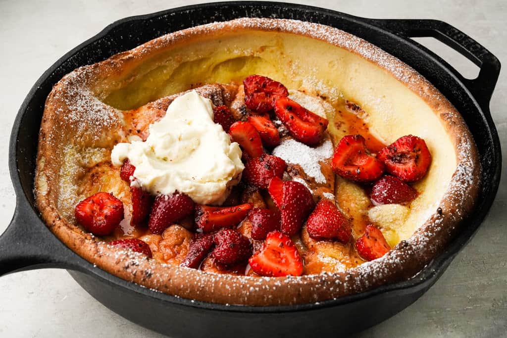 strawberry dutch baby in a cast iron skillet