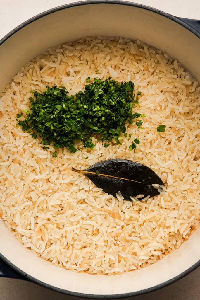 chopped cilantro on top of a pot of cooked rice