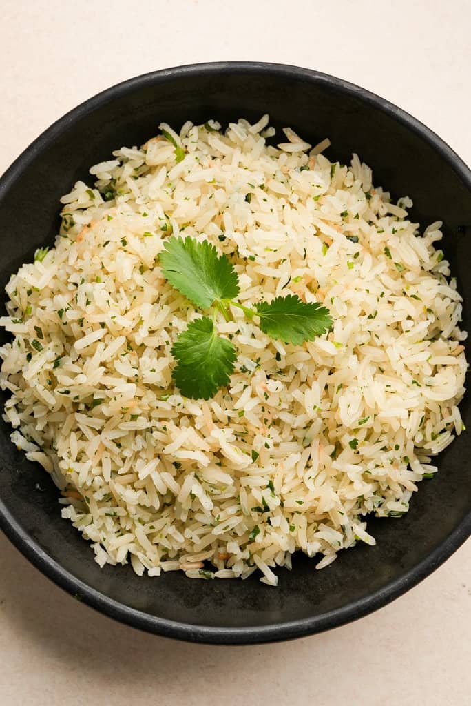 a plate of cilantro lime rice garnished with cilantro leaves