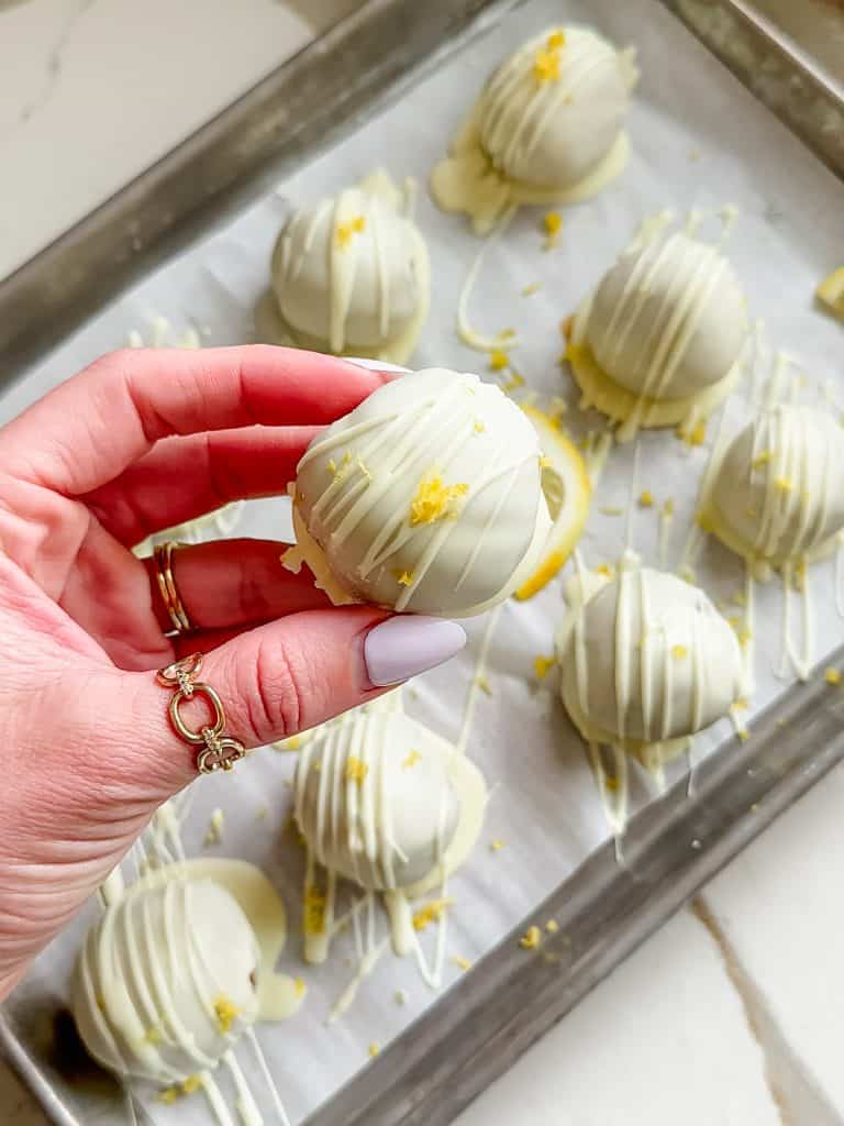 a hand holding one of the lemon truffles