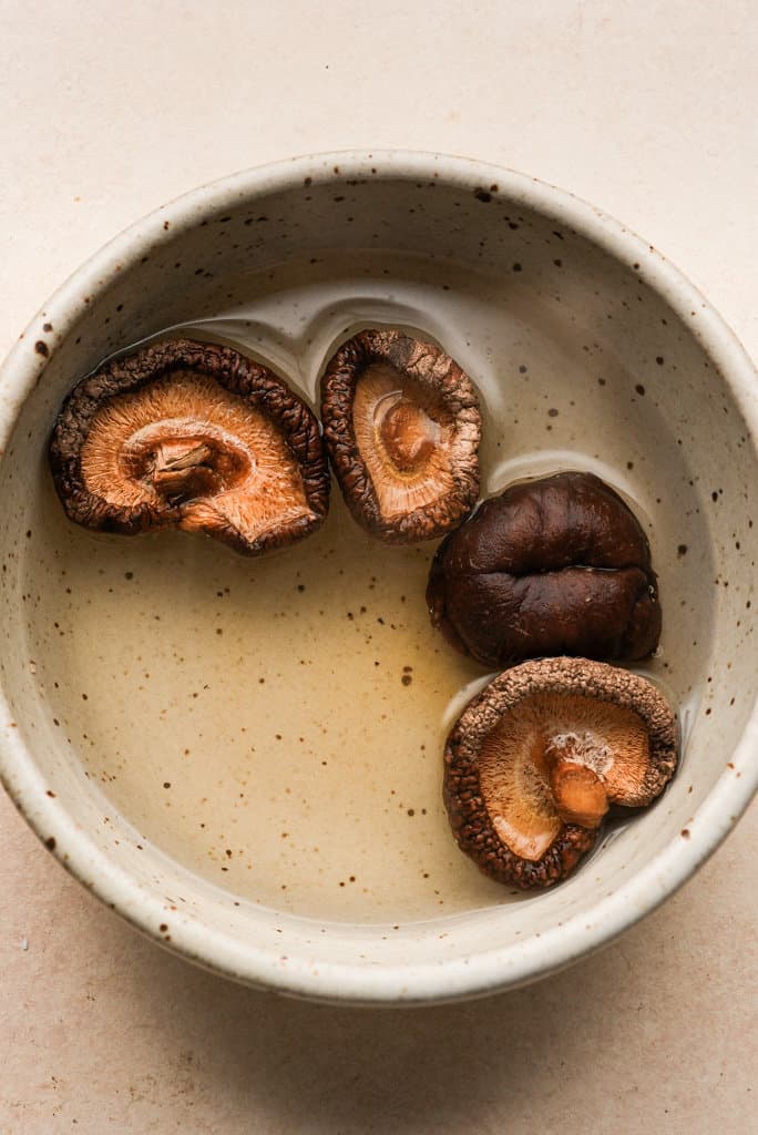 shiitake mushrooms soaking in a bowl of water