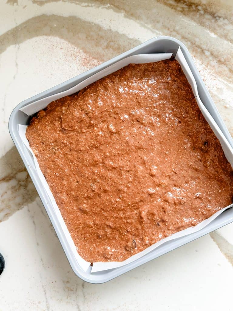 brownie batter poured into prepared baking pan. 